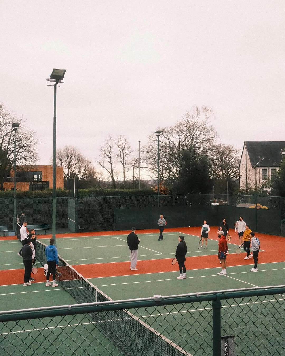 Tennis court with serving folks chatting
